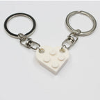Couple heart keychains held in hand close‑up